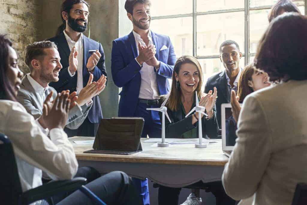 Group of multiethnic coworkers applauding the success of a sustainable project