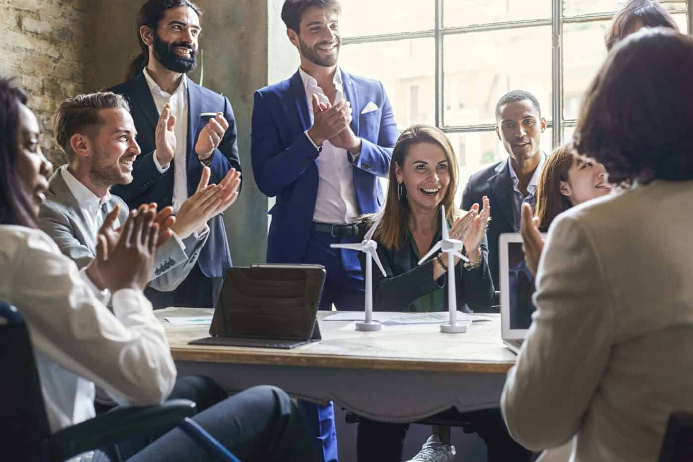 Group of multiethnic coworkers applauding the success of a sustainable project
