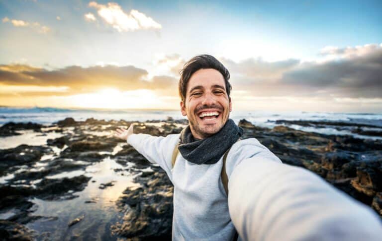 Handsome young man taking selfie pic with smart mobile phone outdoors