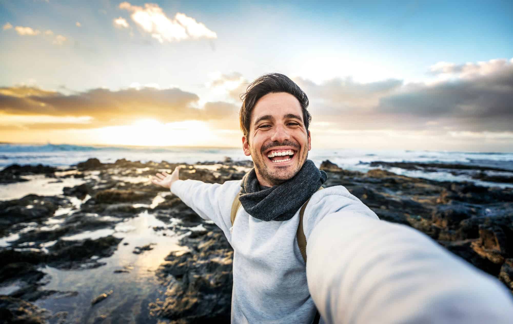 Handsome young man taking selfie pic with smart mobile phone outdoors